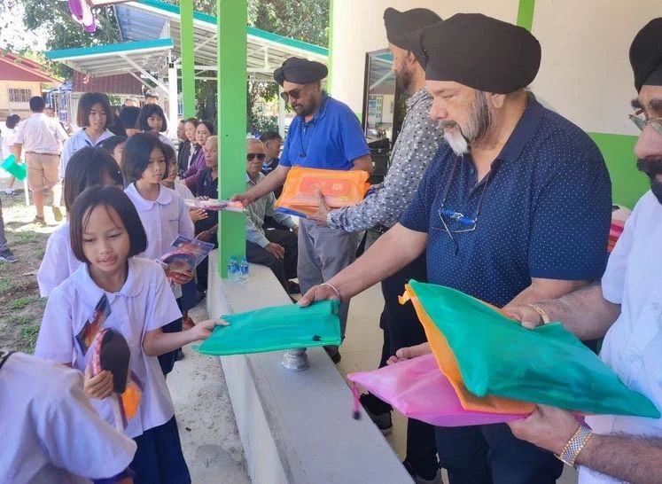 Distributing supplies to students at Ban Hat Kuan